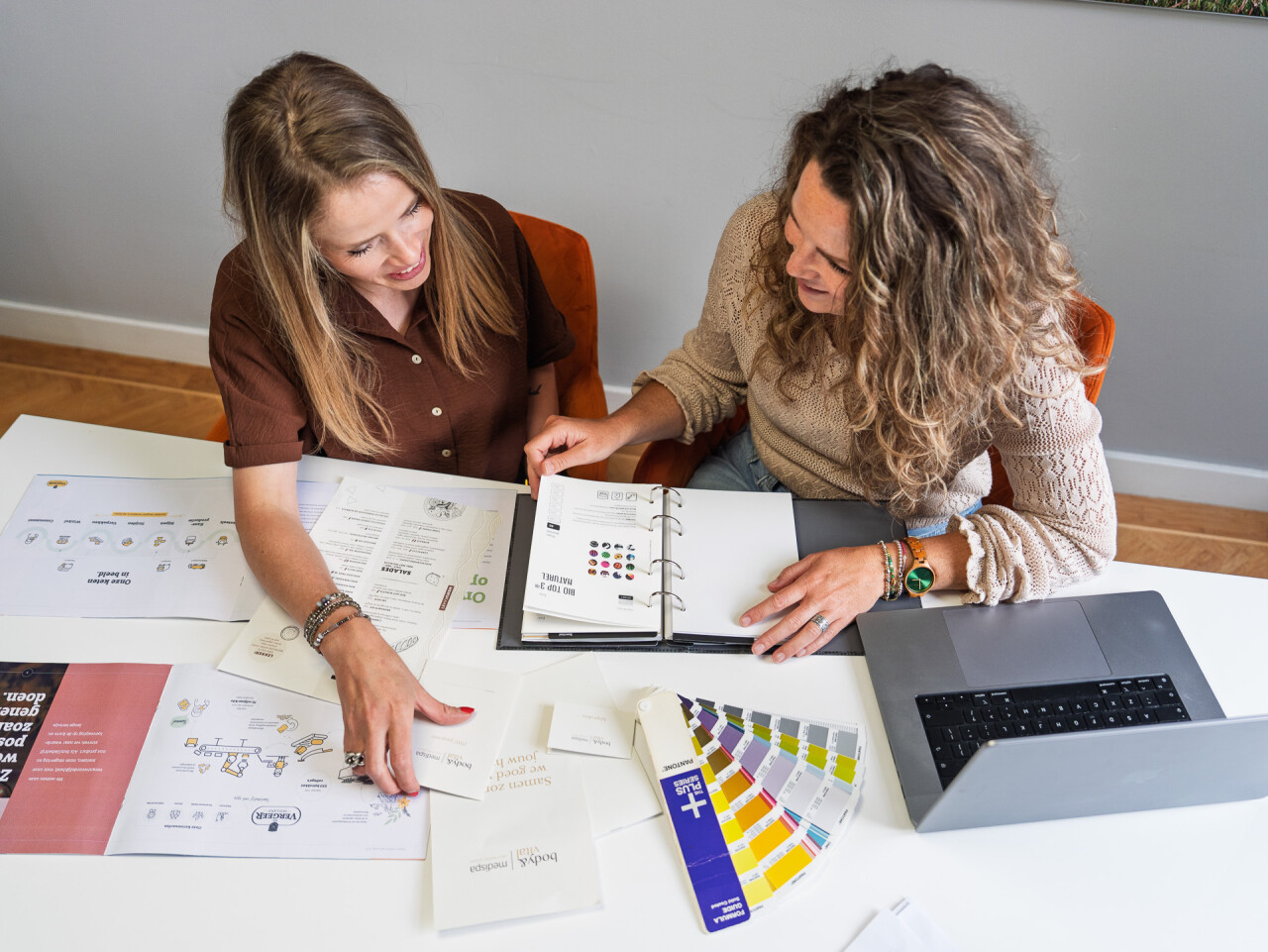 Pencilpoint collega's die overleggen over drukwerk en design